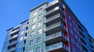 Immeuble coloré offrant des options de location meublée avec balcons spacieux.